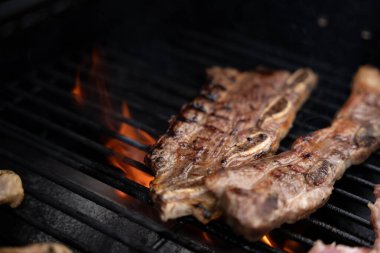 Kuzu kaburgaları sıcak ızgaranın üstünde cızırdıyor. Havada yükselen duman yaz barbeküsü ya da açık hava yemek ziyafeti için mükemmel.