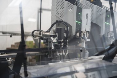 Gelişmiş mühendislik ve üretim hatlarında kullanılan modern imalat sistemlerinin karmaşıklığını ve hassasiyetini vurgulayan endüstriyel otomasyon sürecindeki robotik bir kolun ayrıntılı bir görüntüsü