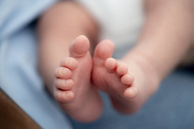 Bu görüntü, yeni doğmuş bir bebeğin huzurlu ve hassas bir anında ayaklarını yakalıyor. Odak noktası, küçük ayak parmakları ve yumuşak cilt, erken yaşamın hassasiyetini ve masumiyetini vurguluyor.. 
