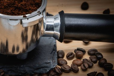 Kahve öğütücü ile kavrulmuş kahve çekirdekleri.