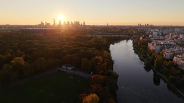 Şehir manzarası ve huzurlu nehir üzerinde gün batımı, güzelliklerle dolu nefes kesici bir manzara.