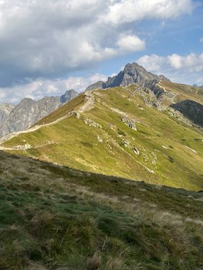 Yamaçlarında gür yeşil çimlerle kaplı çarpıcı bir dağ güzel bir doğal manzara yaratıyor.