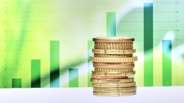 Yığılan paralar, ekonomik performansta yükselen bir eğilimi gösteren yeşil çubuk grafiklerinin önüne konan mali başarı ve yatırım büyümesini simgeliyor..