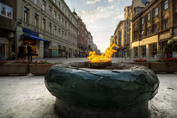 İnsanlar güneşli bir günde yürürken Saraybosna 'nın merkezindeki sonsuz alev