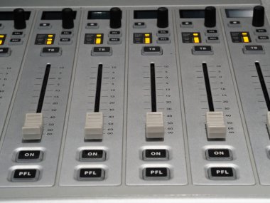 Kontrol panelinde ses mühendisinin stüdyoda bir kayıt sırasında ses seviyesini optimal karıştırma için ayarladığı birkaç fader ve düğme gösterilir..