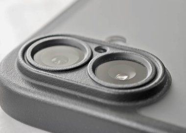 Yakın çekim bir akıllı telefon kamerasının çift lensli sistemini gözler önüne sererek, gelişmiş fotoğrafçılık için tasarlanmış teknolojiyi vurguluyor.