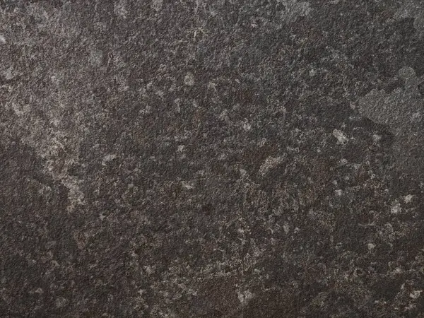 Yüzeyde, düşük ışık koşullarında kayanın doğal güzelliğini vurgulayan, zaman içinde oluşan koyu gölgelerin ve karmaşık desenlerin zengin bir karışımı sergileniyor..