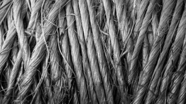 Sıkıca dokunmuş doğal liflerin detaylı bir görüntüsü karmaşık desenleri ve dokuları ortaya çıkarır. Monokromatik renk maddenin görsel karmaşıklığını arttırır.