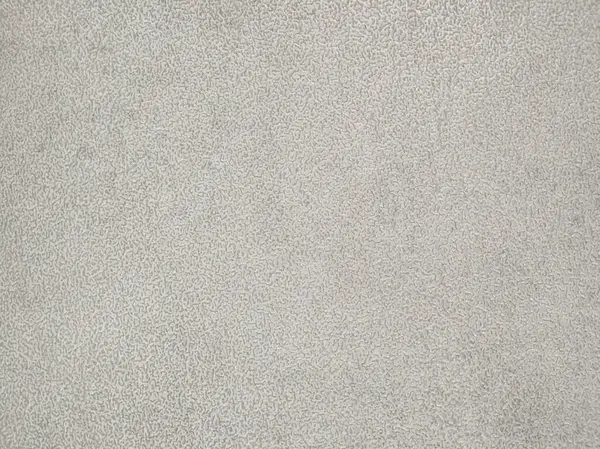 Açık gri bir yüzey, parlak bir ortamda sakin ve minimalist bir görsel deneyim sağlayarak, doğal ışık tarafından aydınlatılan hassas doku ve desenleri sergiler..