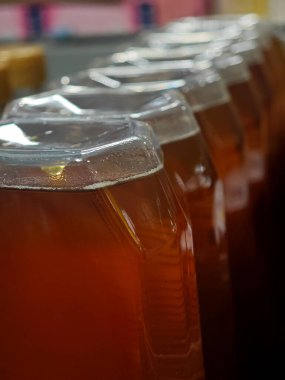 Altın balla dolu birkaç şişe öğleden sonra kalabalık bir markette bir rafta düzgünce sıralanır..