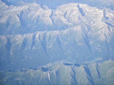 Tepesinde kar olan bir dağ sırası. Dağlar çok yüksek ve onları kar kaplıyor.