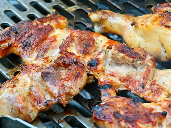 Izgarada bir tavuk askısı var. Tavuk kahverengi ve gevrek.