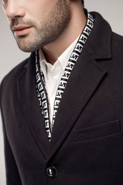 Stüdyoda havalı kıyafetler giyen manken adamın kırpılmış görüntüsü. 