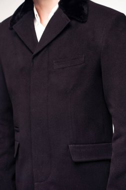 Stüdyoda havalı kıyafetler giyen manken adamın kırpılmış görüntüsü. 