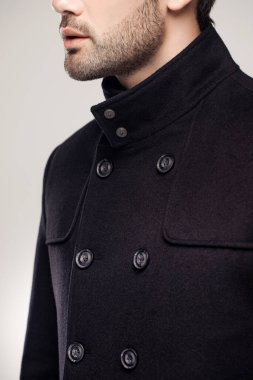 Stüdyoda havalı kıyafetler giyen manken adamın kırpılmış görüntüsü. 