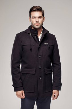 Moda stüdyosunda Avrupalı modelin şık, koyu renk ceketli fotoğrafı.  