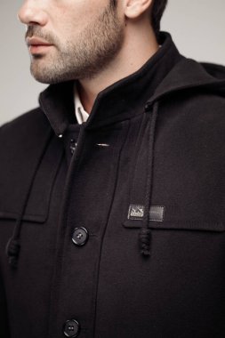 Stüdyoda havalı kıyafetler giyen manken adamın kırpılmış görüntüsü. 