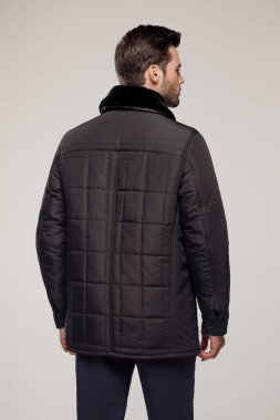 Sonbahar ya da kış mevsiminde havalı siyah ceketli bir adamın moda stüdyosu fotoğrafı. 