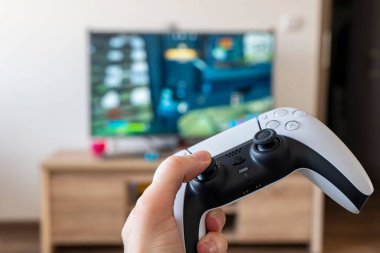 OSTRAVA, CZECH REPUBLIC - 17 Mart 2022: Sony PlayStation 5 konsolunda bilgisayar oyunu oynamak için kullanılan bir elde DualSense denetleyici