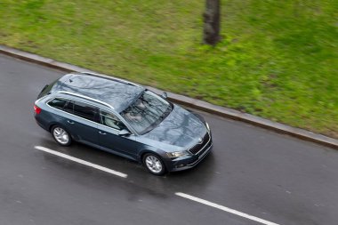 OSTRAVA, CZECH REPUBLIC - MARCH 23, 2024: Dark blue Skoda Octavia Combi estate car with motion blur effect on wet road clipart