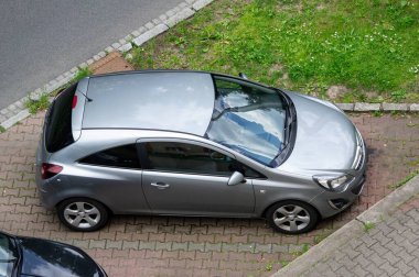 OSTRAVA, CZECHIA - 28 Mayıs 2024: Gümüş Opel Corsa D hatchback arabası caddeye park edilmiş, üst taraf görünümü