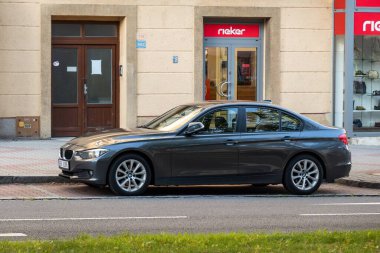 OSTRAVA, CZECHIA - OCTOBER 3, 2023: Grey BMW 3-Series saloon E90 parked in front of Rieker store clipart