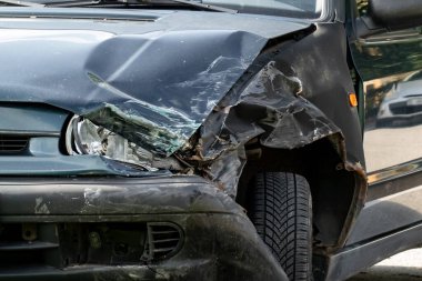 Trafik kazasından sonra kırık far ve tampon ayrıntıları.