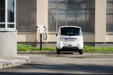 OSTRAVA, CZECHIA - Citroen C-Zero mini electric car near Olife Energy AC charger clipart