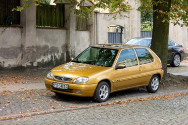 POZNAN, POLAND - 12 AĞUSTOS 2018: Sarı altın rengi Citroen Saxo 1.1i, caddeye park edilmiş Fransız mini arabası.