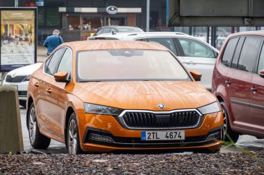 OSTRAVA, CZECH REPUBLIC - 10 Ekim 2023: Turuncu Skoda Octavia asansörü dükkanların önüne park etti