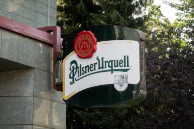 OSTRAVA, CZECHIA - SEPTEMBER 22, 2023: Damaged banner of Pilsner Urquell company at bar in Ostrava where people drink and relax clipart