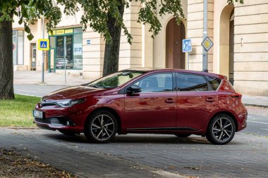 OSTRAVA, CZECHIA - 21 AĞUSTOS 2023: Kırmızı Toyota Auris E180 hatchback hibrid araba sokağa park edildi
