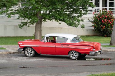 HAVANA, CUBA - 28 AĞUSTOS 2023: Havana, Küba sokaklarında kırmızı Chevrolet Bel Air 1958 model klasik araba, paslı araç
