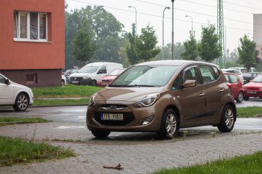 HAVIROV, CZECHIA - 28 Temmuz 2016: Kahverengi Hyundai ix20 MPV arabası yağmur altında sokağa park edildi