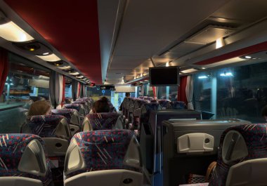 OSTRAVA, CZECHIA - OCTOBER 26, 2024: Interior of Setra S415 GT-HD luxury bus of Leo Express transportation company with people on board at night clipart