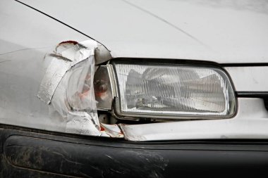 Trafik kazasından sonra gümüş yolcu arabasındaki kırık far ayrıntıları