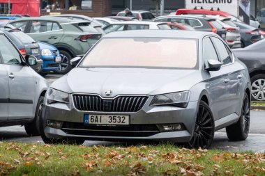 OSTRAVA, CZECHIA - 19 Ekim 2023: yağmurlu caddeye park edilmiş Silver Skoda Superb III kaldırma aracı