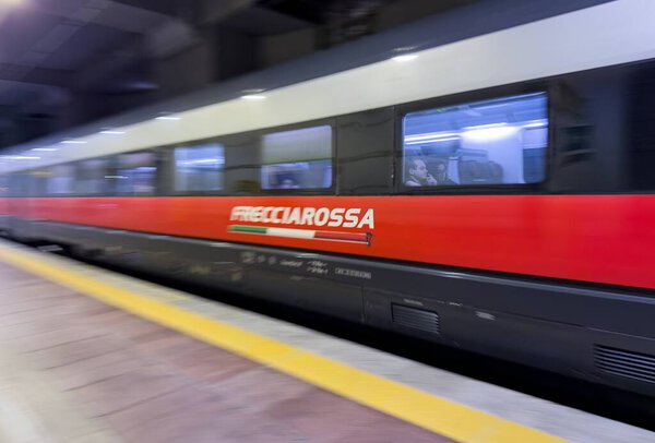 БОЛОНЬЯ, ИТАЛИЯ - 27 ОКТЯБРЯ 2024: Красный Frecciarossa ETR 1000 высокоскоростной поезд компании Trenitalia на центральном железнодорожном вокзале Болоньи, тяжелое размытие движения