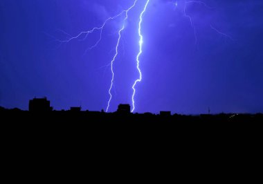 Geceleri Havirov 'un şehir manzarasıyla yere düşen yıldırım.