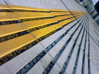 Sarı çizgili bir tren istasyonunda asfalt detayı.