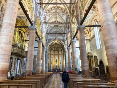 VERONA, ITALY - OCTOBER 28, 2024: La Basilica di Santa Anastasia cathedral, interior with benches and visitors clipart