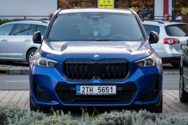 OSTRAVA, CZECHIA - OCTOBER 17, 2023: BMW X1 U11 SUV crossover with blue colour parked on street, frontal view clipart