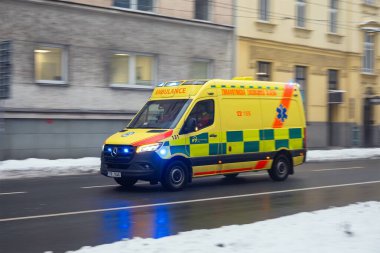 OSTRAVA, CZECH REPUBLIC - 7 Aralık 2023: Mercedes-Benz Sprinter ambulans aracı ıslak kış yolu üzerinde hareket bulanıklığı etkisi