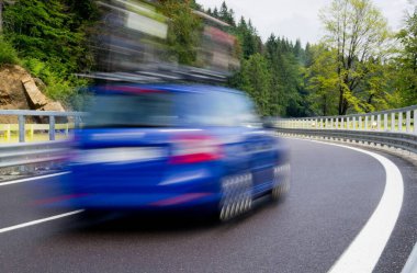 Hızlı hareket bulanık mavi araba virajlı dağ yolunda çatıda bisikletlerle