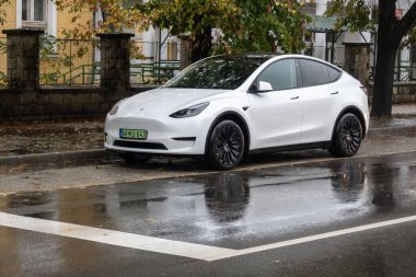 TOKAJ, HUNGARY - 27 Ekim 2023: Macar yeşil EV plakalı beyaz Tesla Model Y elektrikli SUV 