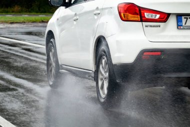 OSTRAVA, CZECHIA - 20 Kasım 2023: Mitsubishi ASX 'in hareket bulanık hareket eden tekerleği, şiddetli yağmur altında su sıçratıyor