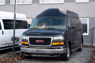 OSTRAVA, CZECHIA - 28 ARALIK 2023: Ostrava 'daki bayiliğin önünde Siyah GMC Savana 3500 LWB yolcu minibüsü