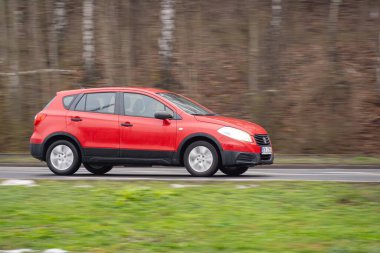 OSTRAVA, CZECHIA - 14 Aralık 2023: Kırmızı Suzuki SX4 S-Cross hareket bulanıklığı efektli çapraz araba