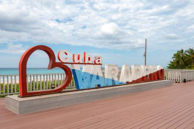 VARADERO, CUBA - 30 Ağustos 2023: Küba 'da kırmızı büyük kalp ve kumsal manzaralı Varadero tabelası