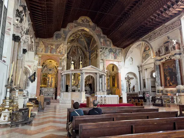 VERONA, İtalya - 28 Ekim 2024: San Fermo Maggiore Katedrali, sunakla iç mekan ve ziyaretçilerle banklar